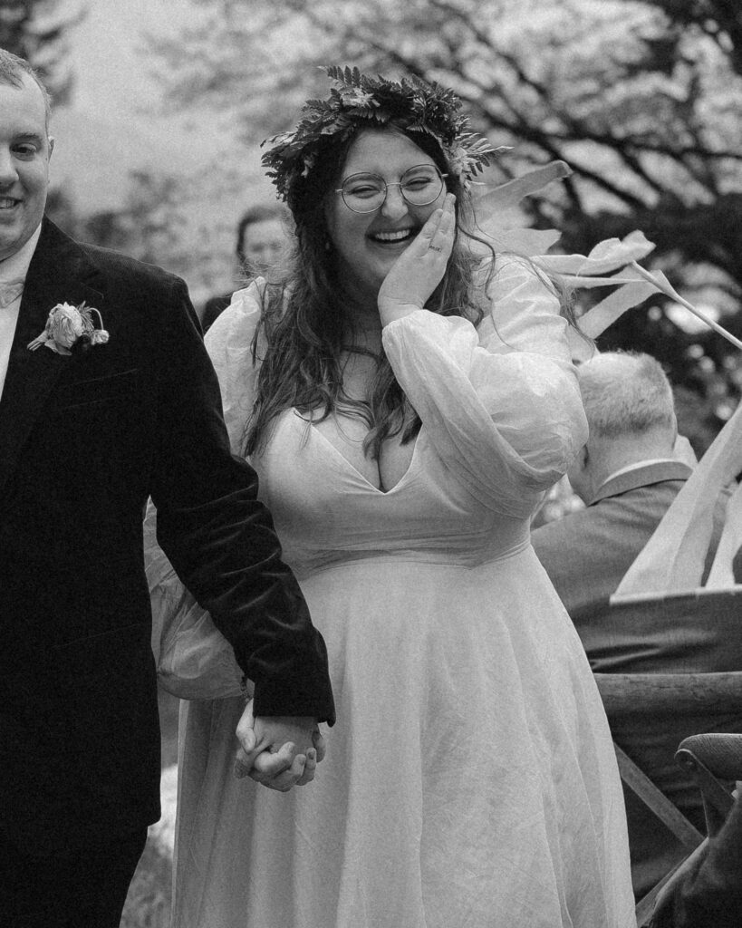 A bride showing joy and bliss as she walks back down the aisle during her ceremony taking place on private property in the Columbia River Gorge, Oregon. 