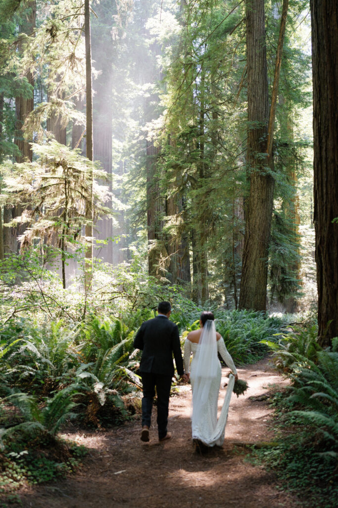 Couple walking a forest trail on their adventurous forest elopement day. 