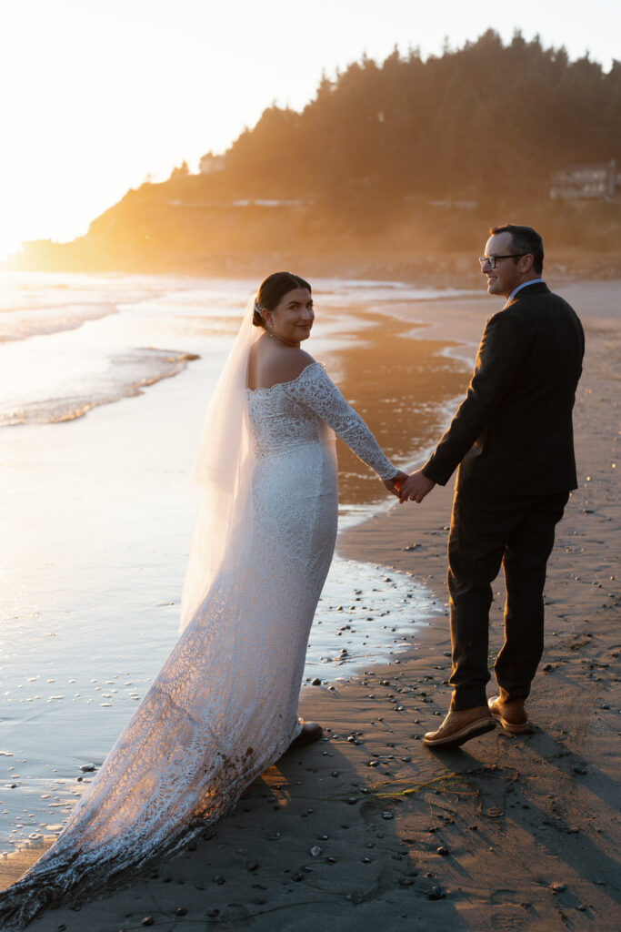 Couple walking the private beach at sunset on their Crook Point wedding day.