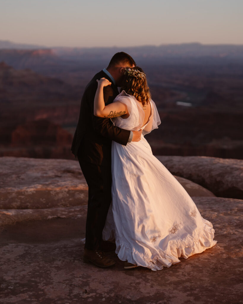 Portrait of couple at sunset in desert during their small wedding.