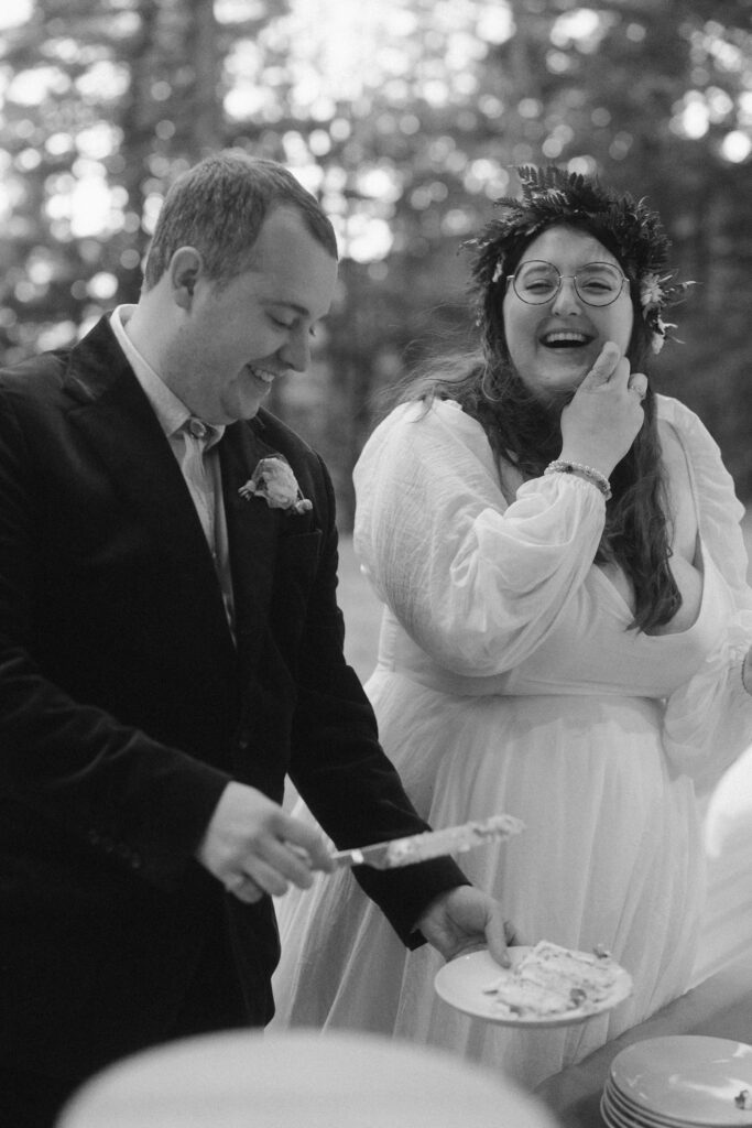 black and white portrait of couple cutting micro wedding cake