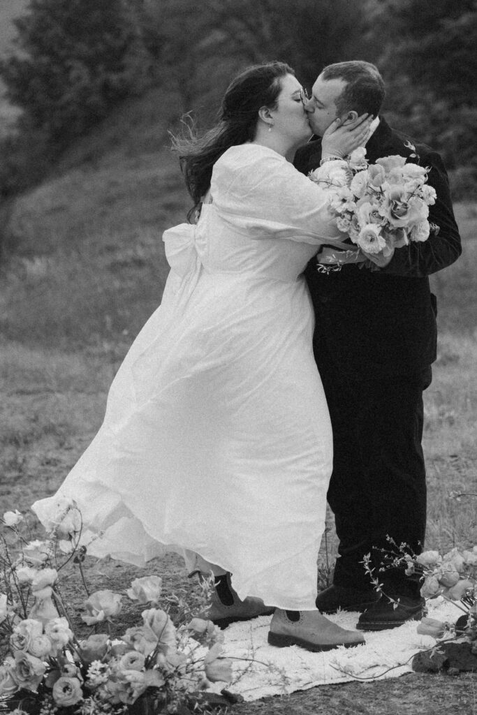 bride and groom elopement ceremony first kiss in black and white