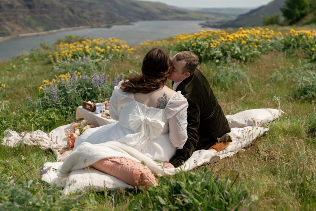 bride and groom enjoying a luxury elopement picnic in a wildflower meadow at Rowena Crest in the Columbia River Gorge Oregon