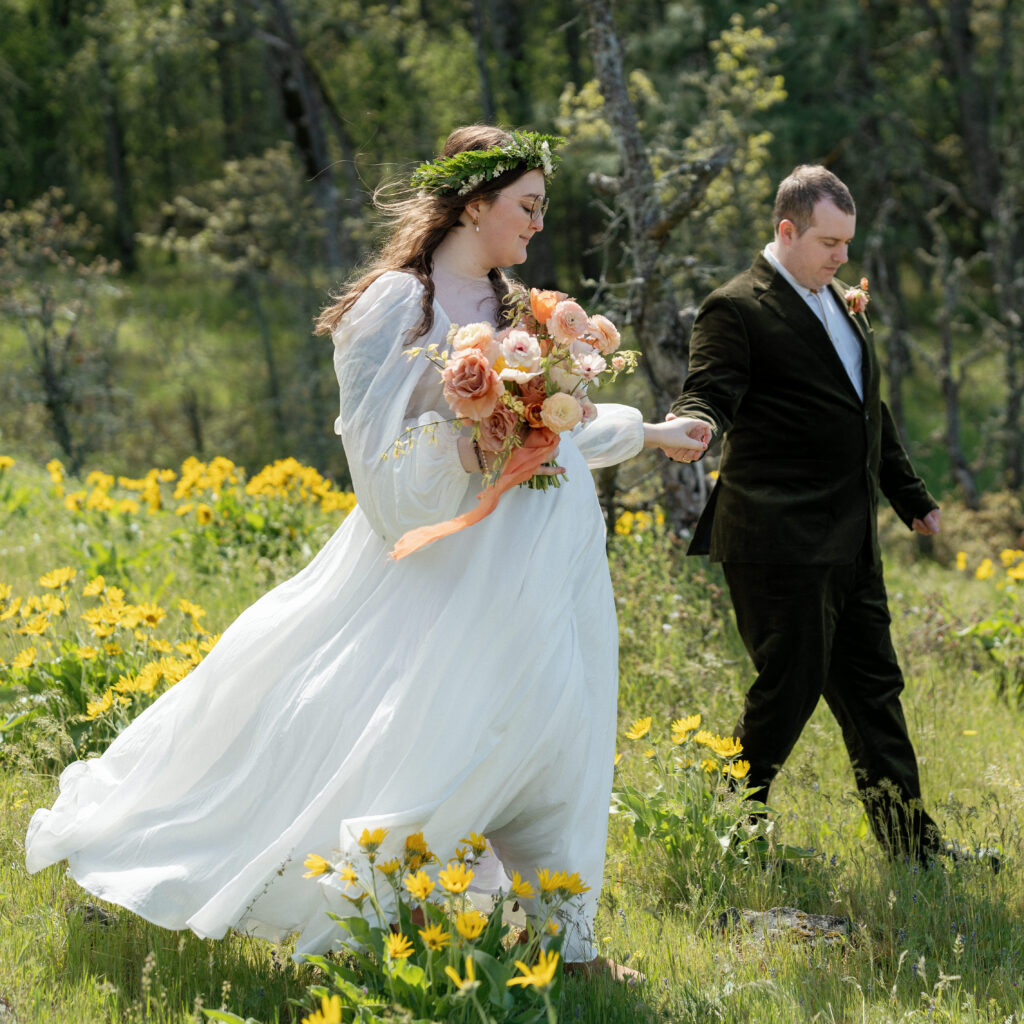 bride and groom at their Rowena Crest wedding in the Columbia River Gorge Oregon walking through a wildflower meadow